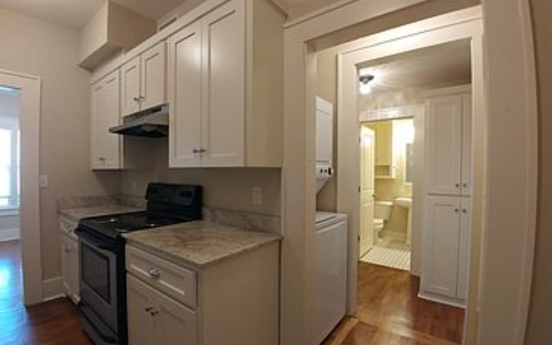 Charming historic apartment kitchen with modern appliances, granite countertops, and access to bathroom and laundry area, located in the Argenta District of North Little Rock.