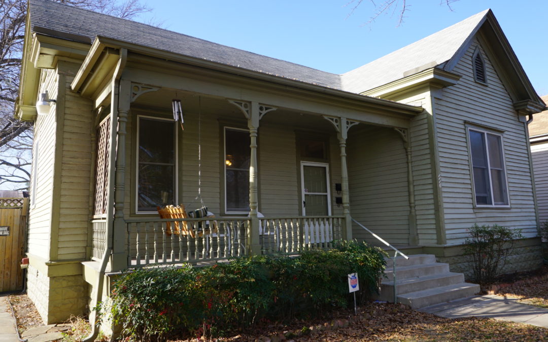 Renovated duplex exterior in The Heights, featuring a charming porch, decorative woodwork, and lush greenery, highlighting its appeal for potential renters in Little Rock.
