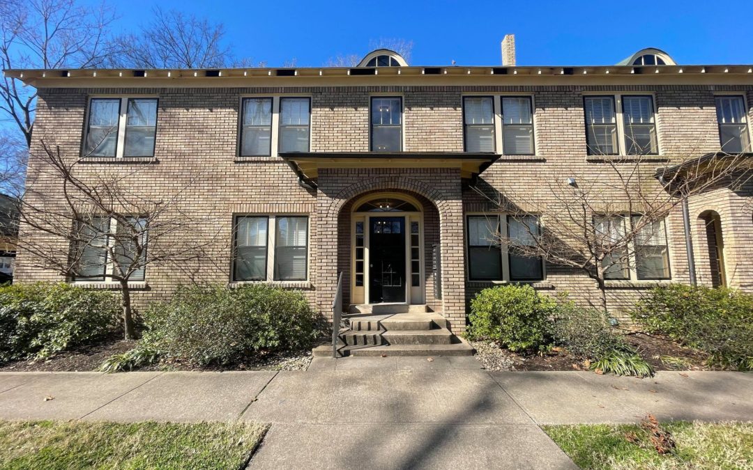 Charming brick apartment building exterior with a welcoming entrance, surrounded by greenery, showcasing a recently renovated property available for lease.