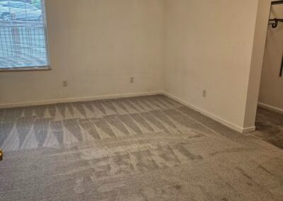 Renovated interior of a 3-bedroom duplex in Midtown Little Rock, featuring freshly carpeted flooring and natural light from a window.