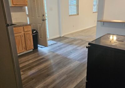 Newly renovated duplex interior featuring modern flooring, kitchen area with wooden cabinets, and bright natural light from windows, ideal for renters in Midtown Little Rock.