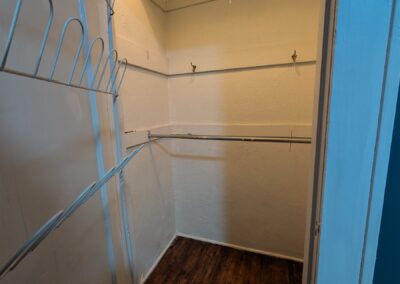 Interior view of a spacious closet with shelving and hanging rods, suitable for storage in a one-bedroom duplex near UALR.