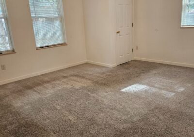 Spacious, newly renovated living area in a duplex rental, featuring large windows, soft carpet, and a bright atmosphere, ideal for comfortable living in Midtown Little Rock.