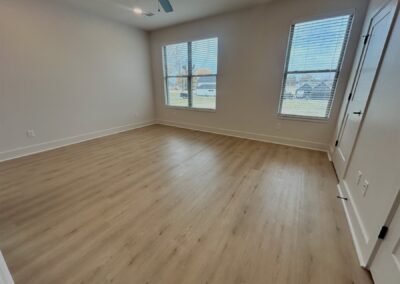 Spacious interior of a brand-new townhome in Argenta District, featuring hardwood flooring and ample natural light from large windows.