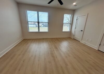 Spacious interior of a brand-new townhome in Argenta featuring hardwood flooring, large windows providing natural light, and modern design elements.