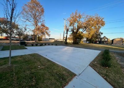 Brand-new townhome exterior in Argenta District, showcasing modern landscaping, concrete driveway, and surrounding trees, emphasizing rental property features.