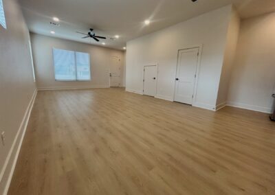 Spacious interior of a brand-new townhome in Argenta, featuring hardwood flooring, large windows, and modern design elements.
