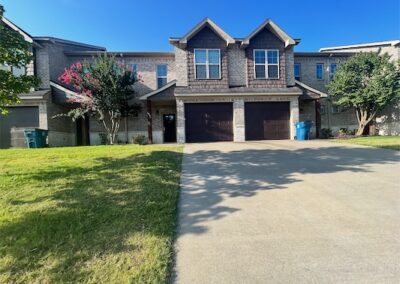 Spacious townhome exterior in Benton, Arkansas, featuring a modern design, attached garage, manicured lawn, and vibrant landscaping.