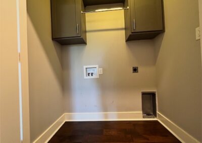 Spacious laundry area in Benton townhome featuring modern cabinetry and hardwood floors.