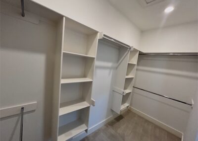 Spacious walk-in closet with built-in shelves and hanging space in a modern Benton, Arkansas townhome rental.
