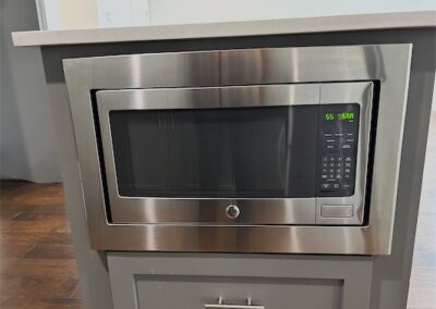 Microwave oven built into kitchen cabinetry, featuring stainless steel finish and digital controls, highlighting modern amenities in a Benton, Arkansas townhome for rent.