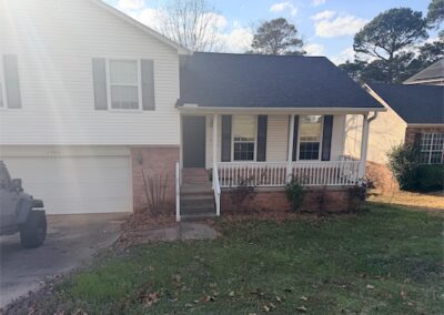 Two-story West Little Rock home featuring a front porch, landscaped yard, and attached two-car garage, showcasing a welcoming exterior with a blend of brick and siding.