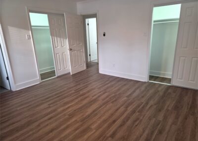 Modern interior of a 3-bedroom, 2-bath home in West Little Rock featuring new hardwood flooring, spacious layout, and multiple closet doors, highlighting contemporary upgrades and move-in readiness.