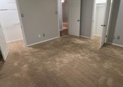 Spacious carpeted interior of a single-family home in West Little Rock, featuring neutral walls and multiple doorways leading to additional rooms.