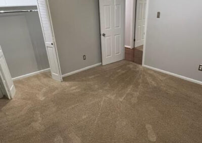 Spacious carpeted room in single-family home with closet and doors leading to adjacent areas, showcasing interior layout for rental in West Little Rock.