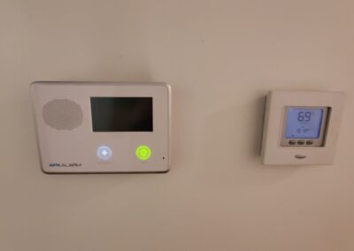 Thermostat and control panel on wall, showcasing temperature setting of 69 degrees, relevant for single-family home rental in West Little Rock.